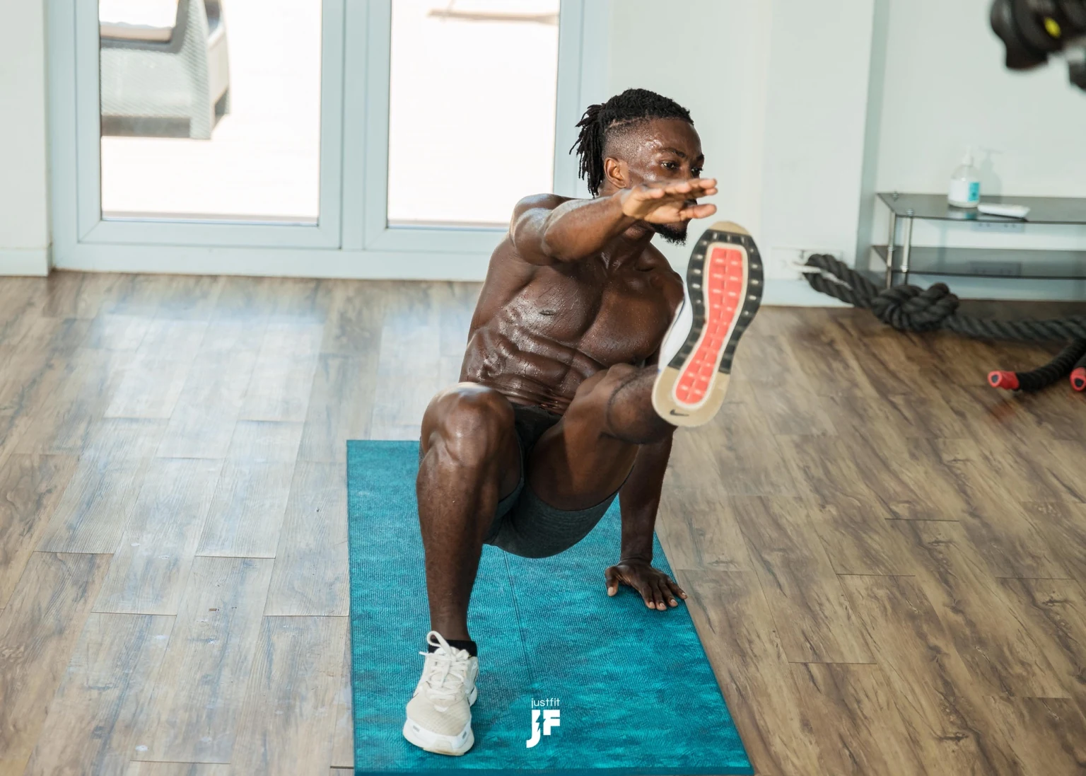 Lymon demonstrating a bodyweight balance exercise on a mat